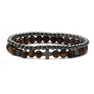 Detail of punk bead bracelet set featuring brown tiger eye stones and a metal cross charm