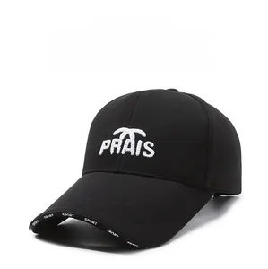 Dettaglio cappello nero con ricamo PRAIS bianco e logo SPORT sulla tesa della visiera