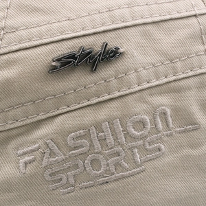 Close-up of beige cotton baseball cap with metal Style tag and Fashion Sports embroidery