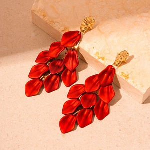 Detailed macro shot of red acrylic flower petal tassel earrings with gold studs