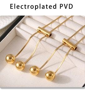 Detail of PVD electroplated 18K gold sweater necklace with sphere and tassel elements