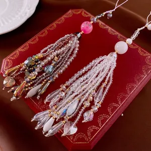 Elegant beaded butterfly crystal tassel phone charm with heart elements on a gift box