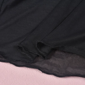Close-up of black mesh fabric showing fine net structure and wavy lettuce edge stitching