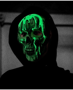 Close-up of Halloween skull mask featuring neon green glowing liquid drip textures