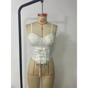 Dettaglio canotta in pizzo bianco con lacci frontali e orlo stile corsetto