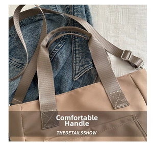 Close-up of light brown tote bag with reinforced handles and metal strap buckles