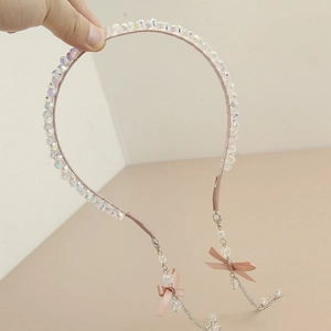 Detail of pink crystal headband featuring ribbon bows and elegant chain tassels