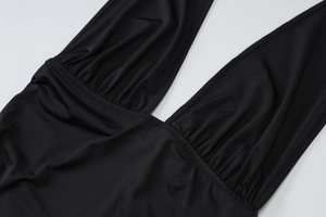Close-up of deep V-neckline with pleated details on black sleek sleeveless camisole