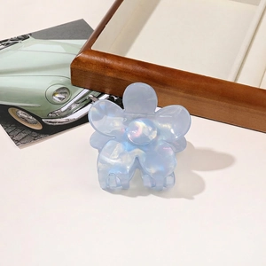 Close-up of a light blue iridescent flower hair claw clip with a pearlescent finish