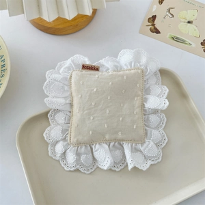 Detail of cream coasters with heart lace embroidery and embossed polka dots