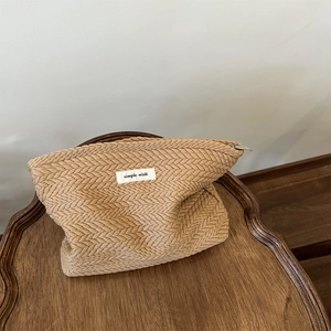 Beige woven straw pouch with simple wish label on dark wood tabletop