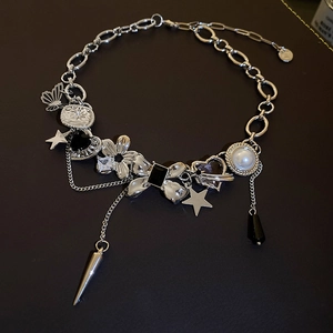 Detailed view of silver punk necklace with bow, star, and heart charms on a mixed chain