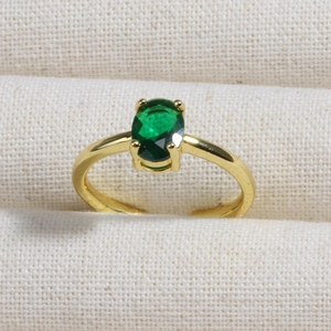 Macro shot of an oval emerald green zircon ring set in 18K gold plated copper