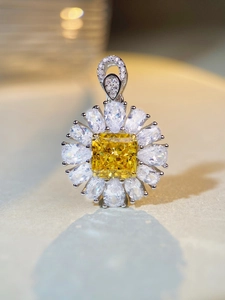 Macro shot of S925 silver sunflower pendant with square yellow stone and pear-cut diamonds