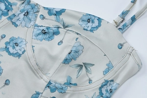 Détail du motif floral bleu et de la couture du décolleté sur cette robe d'été