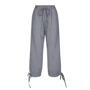 Detail view of grey linen wide leg pants featuring adjustable drawstring waist and tied cuffs