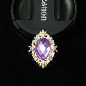 Detailed close-up of a vintage purple gemstone brooch with a golden crystal frame