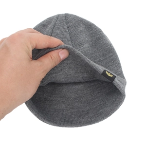 Grey winter knitted beanie with brand tag shown being stretched to display fabric elasticity
