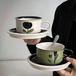 Detail of vintage hand-painted ceramic coffee cup set with black tulip floral patterns