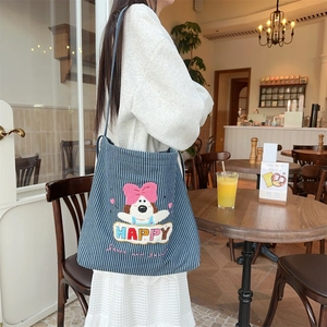 Close-up of cute cartoon puppy embroidery and colorful letters on striped canvas bag