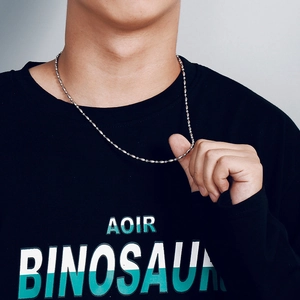 Polished stainless steel beaded bamboo chain necklace worn by a male model for scale