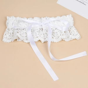 Detailed close-up of white floral lace elastic garter with satin ribbon bow tie detail