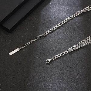 Detailed view of silver double-layered necklace with figaro chain and lobster clasp