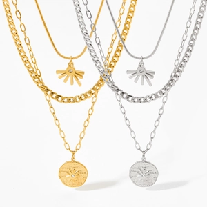 Detail of layered sun and star pendant necklaces in gold and silver finish