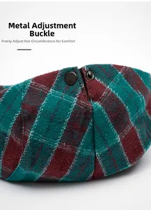 Close-up of metal adjustment buckle on red and green plaid newsboy cap detail