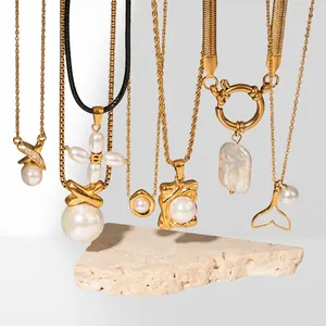 Collection of 18K gold plated pearl necklaces with diverse charms on a stone display