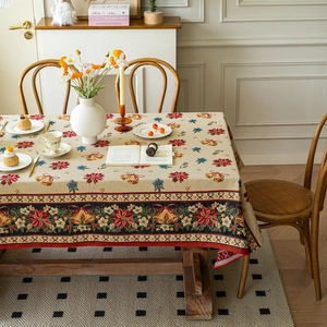 Vintage Christmas jacquard tablecloth with poinsettia and bell patterns on a wooden table