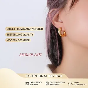 Close-up of chunky gold hoop earring with polished finish on a model's earlobe