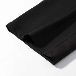 Dettaglio delle cuciture piatte professionali e del tessuto nero denso sull'orlo dei pantaloni