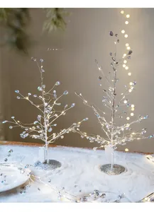 Pair of silver wired Christmas trees with acrylic beads and LED lights on snowy base