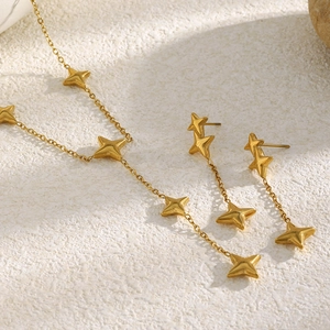 Vue détaillée du lot collier et boucles d'oreilles étoile plaqué or 18K sur texture pierre