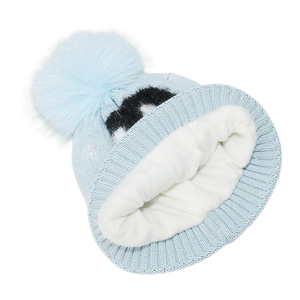 Detail of light blue winter knit hat featuring soft white fleece lining and plush pompom