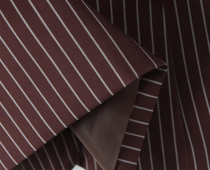 Detail of burgundy striped blazer showing premium fabric texture and interior lining