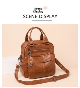 Detail of brown PU leather backpack showing multiple zip pockets and bronze hardware