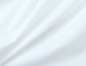 Macro shot of white shirt fabric texture showing soft drape and high-quality textile detail