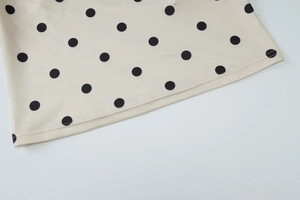 Detaillierte Nahaufnahme der Saumnaht und Polka-Dot-Stofftextur am Sommertop