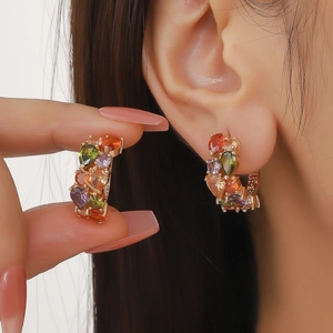 Boucles d'oreilles dorées en forme de C avec cristaux de zircon colorés sur modèle