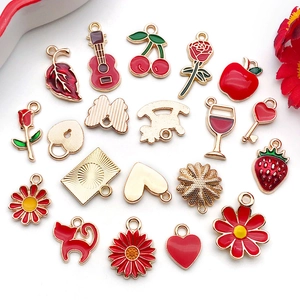 Close-up of red and gold enamel jewelry charms in cherry, heart, and guitar shapes
