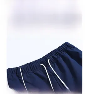 Detail of dark blue casual trousers showing elastic waistband with white drawstring cords