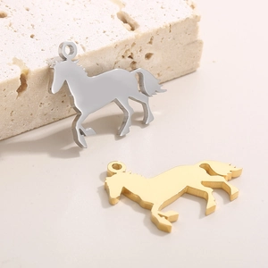 Pendentifs cheval minimalistes en acier inoxydable or et argent sur pierre texturée