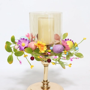 Easter candle ring with colorful eggs and spring flowers on a gold glass holder
