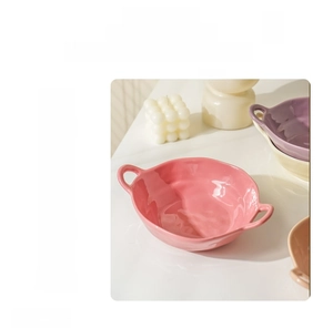 Detail of cute ceramic soup bowl with handles showing microwave and oven compatibility icons
