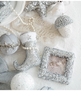 Detail of silver glitter Christmas ornaments with white pearl chains on snow