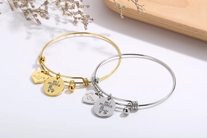 Close-up of gold and silver heart bracelets with Love and mi mama charms for Mother's Day