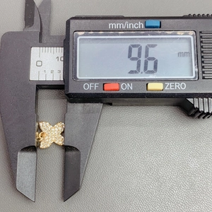 Macro shot showing crystal zircon butterfly charm measuring 9.6 mm with digital caliper