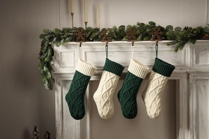 Detail of hanging knitted Christmas stockings with cable patterns on a white fireplace